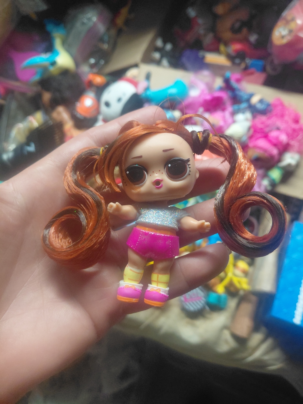 an L.O.L. Surprise! collectible doll featuring styled pigtails and a glittery to